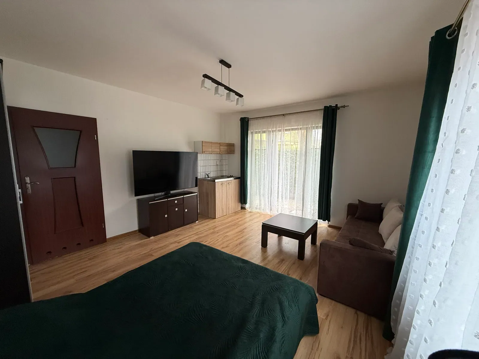 Pokój z aneksem kuchennym i wyjściem na balkon